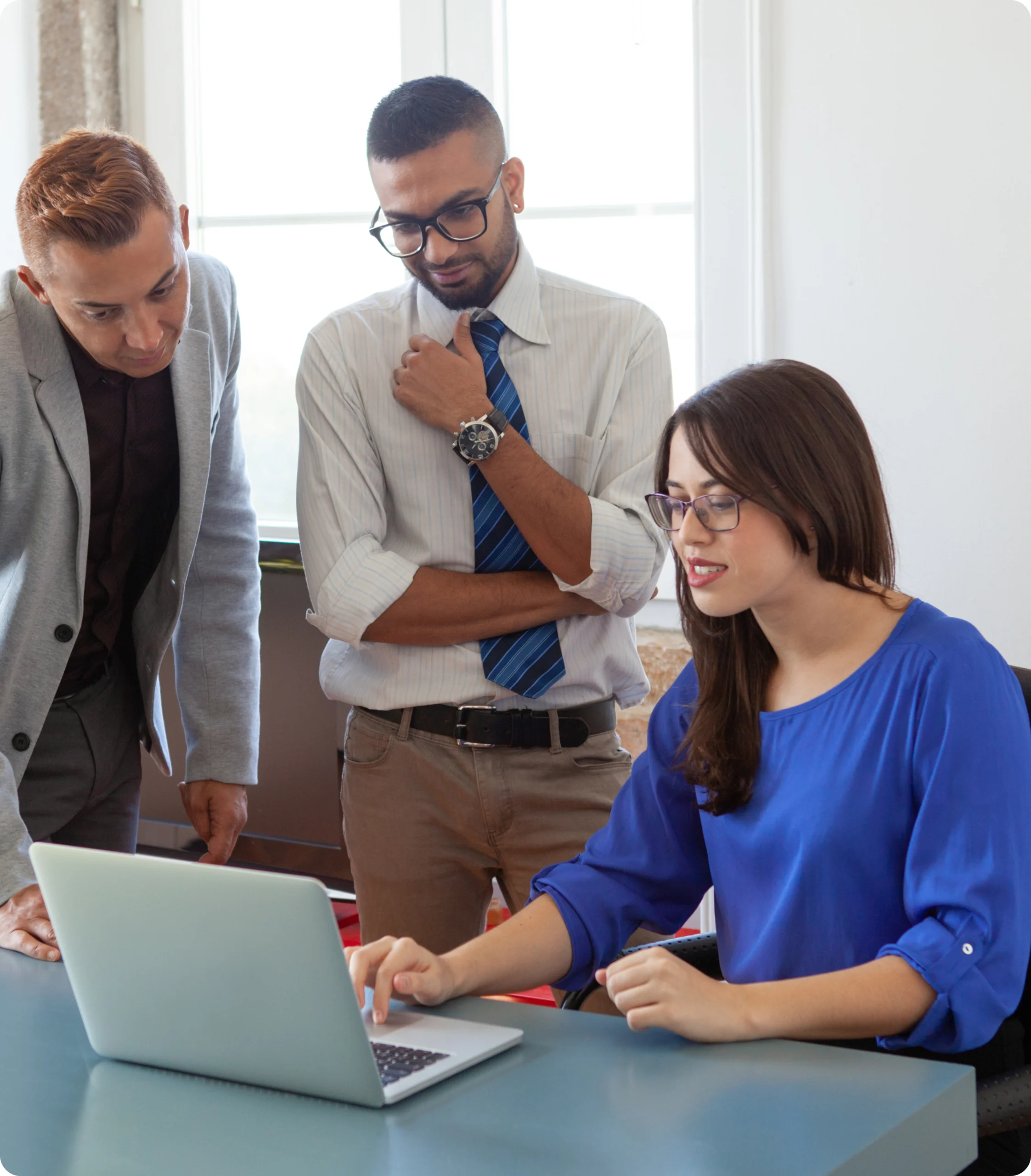 Business team reviewing information together around a laptop